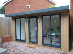 an outdoor room with sliding glass doors on the outside and brick paversed patio