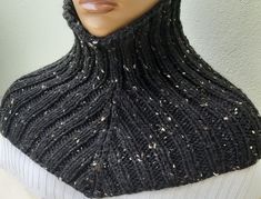 a mannequin wearing a black knitted cowl with white speckles