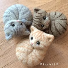 three small stuffed animals sitting on top of a wooden floor