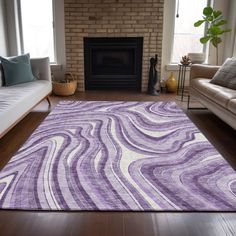 a living room filled with furniture and a purple rug on top of a hard wood floor