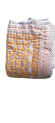 a yellow and white quilted bag sitting on top of a table