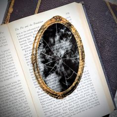 an open book on top of a table next to a black and white photo with gold trim