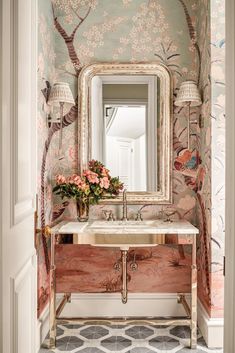 a bathroom sink sitting under a mirror next to a wallpapered wall with birds on it