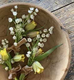 flowers in a wooden bowl on a table