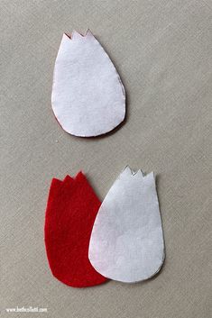 two pieces of felt sitting next to each other on top of a cloth covered surface