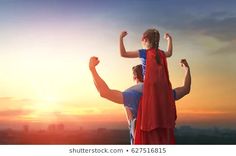 a father and daughter are standing on the top of a mountain at sunset with their arms in the air