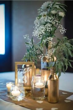 vases filled with flowers and candles on a table