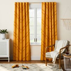 a living room with yellow curtains and a white rug