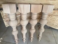 four wooden posts sitting on top of a tile floor next to a piece of wood