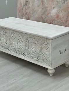 a white chest with ornate carvings on it