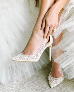 a woman wearing high heels is tying her wedding shoes