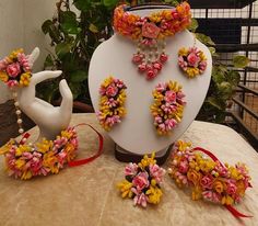 an arrangement of flowers and jewelry on display