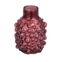 a pink vase is sitting on a white surface and has many balls in the center