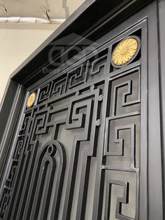 an ornate door is shown in black and gold