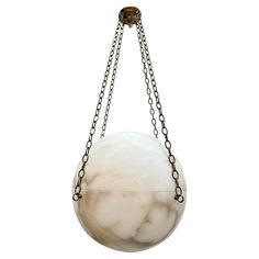 a white marble ball hanging from a chain