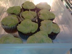 several cupcakes sitting in a plastic container on top of a refrigerator freezer