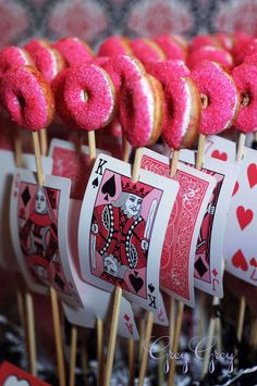 pink donuts and playing cards are on sticks