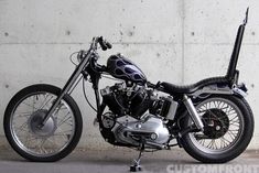 a black and silver motorcycle parked next to a wall