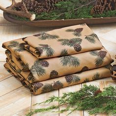 a pile of pine cones sitting on top of a wooden floor next to evergreen branches