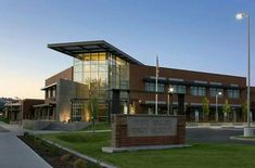 a large building with a flag pole in front of it and grass on the ground