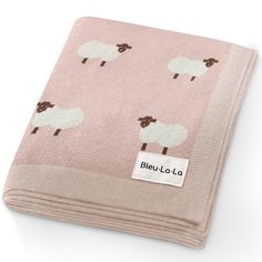 a pink blanket with sheep on it and a label that says beljuloa