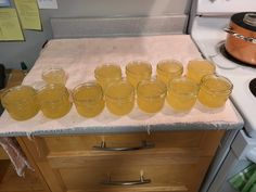 several glasses are lined up on a counter in front of an oven and stove top