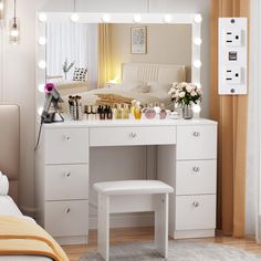 a white vanity with lights on it in a bedroom