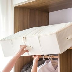 a woman is trying to pull the mattress out of her closet and it's attached to a shelf