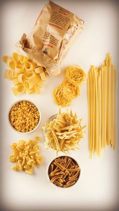 several different types of pasta in bowls on a white surface