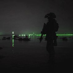 a person standing in the dark with a green light on their head and an island in the background