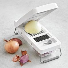 an onion slicer and onions on a table