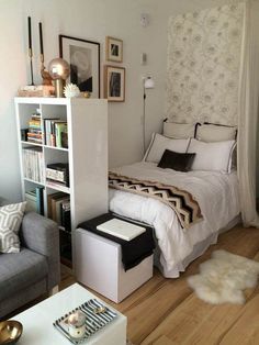 a bedroom with a bed, chair and bookshelf next to a couch in front of a window