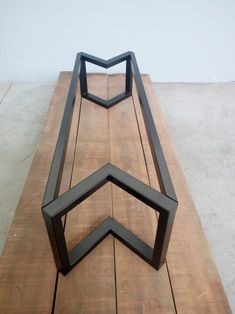 three black metal benches sitting on top of a wooden floor next to each other in front of a white wall