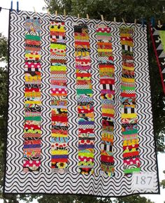 a large quilt hanging from a clothes line