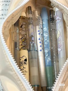 an open zippered pouch filled with various pens