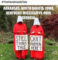 two people in red robes holding signs that read, still think happen here? arkans north dakota iowa kentucky mississippi ohio