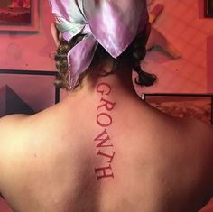 the back of a woman's neck with words written on her upper and lower back