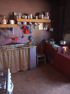 a kitchen with pots and pans hanging on the wall, stove top oven next to it