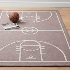 a basketball court rug with a basketball on it and a magazine laying next to it