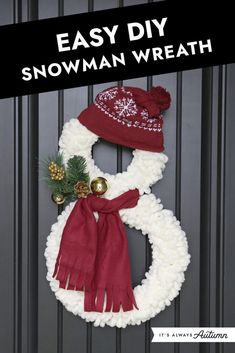 a snowman wreath hanging on a door with a red and white scarf around it