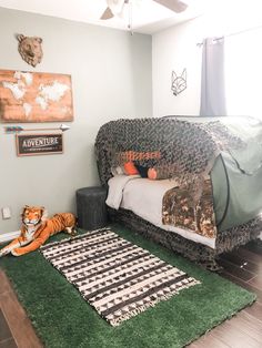 a bedroom with a bed, rugs and a tiger laying on the floor in front of it