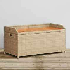 an empty wicker chest on a wooden floor with a white wall in the background