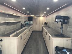 the inside of an rv with wood flooring and white cabinets, lighting fixtures and appliances