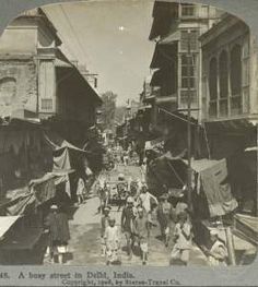 an old black and white photo of people walking down a street