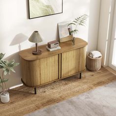 a living room scene with focus on the sideboard and plants in vases next to it