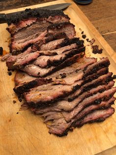 sliced meat sitting on top of a wooden cutting board