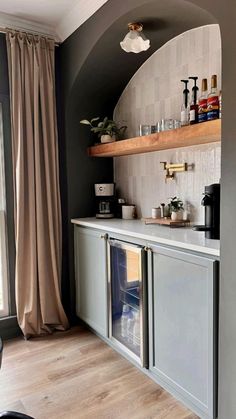 a kitchen with an oven, counter top and shelves on the wall next to a window