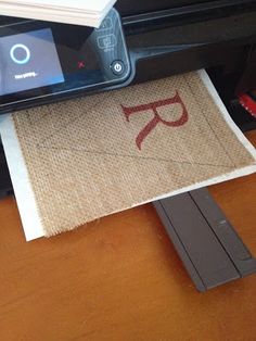 a printer sitting on top of a wooden table next to a piece of paper with scissors