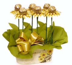 three sunflowers in a pot with gold foiled chocolates on the top