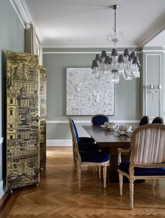 the front cover of luxury interiors and design magazine, with blue chairs around a wooden table